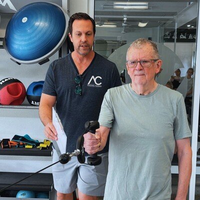 David completing an asymmetric cable row under Aaron's guidance